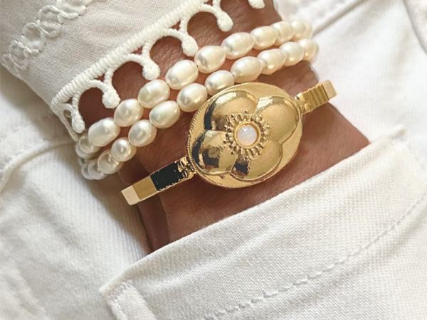 Bracelet doré au design floral et sa perle lumineuse